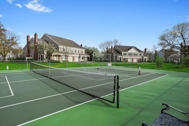 view of sport court with a yard and fence
