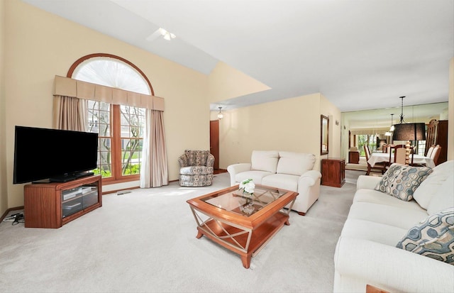 carpeted living area featuring a chandelier and a healthy amount of sunlight