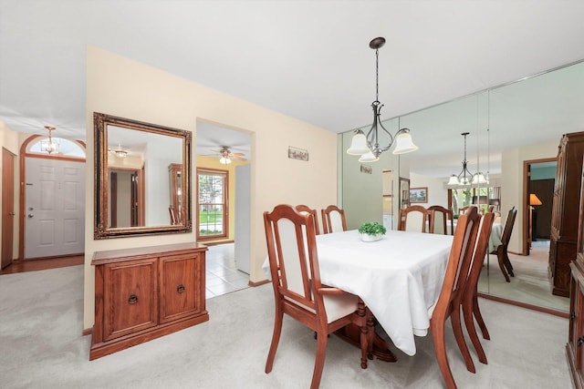 dining room featuring light colored carpet and an inviting chandelier
