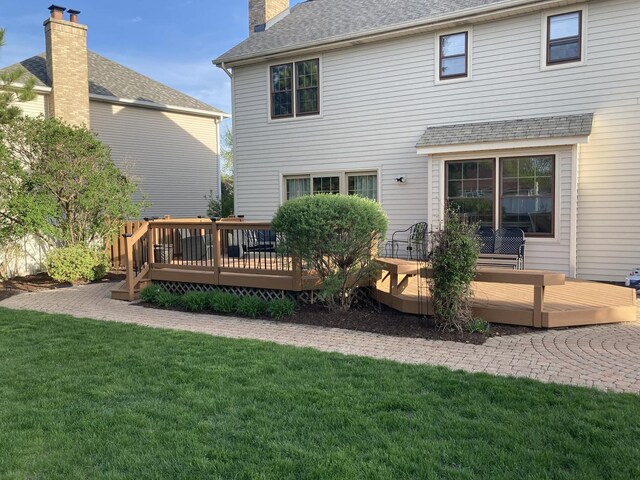 205 Northampton Dr, Oswego, IL 60543 - rear view of house featuring a lawn, a deck, a chimney, and roof with shingles