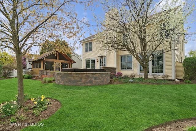 back of house with an outbuilding, fence, and a yard