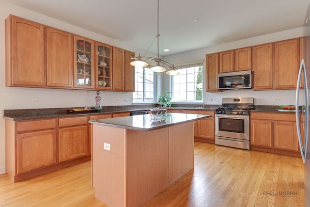 1330 Horizon Trl, Wheeling, IL 60090 - kitchen with light wood-type flooring, appliances with stainless steel finishes, a kitchen island, and glass insert cabinets