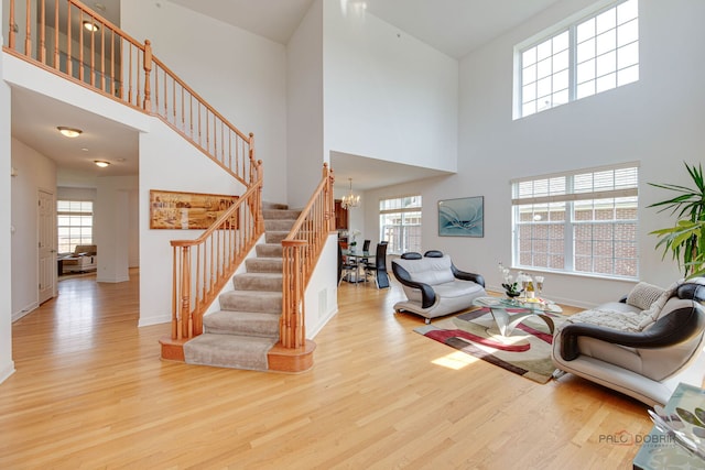 1330 Horizon Trl, Wheeling, IL 60090 - living room featuring a towering ceiling, wood finished floors, stairway, baseboards, and a notable chandelier
