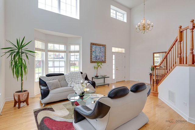 1330 Horizon Trl, Wheeling, IL 60090 - living area with visible vents, light wood-type flooring, a towering ceiling, and an inviting chandelier