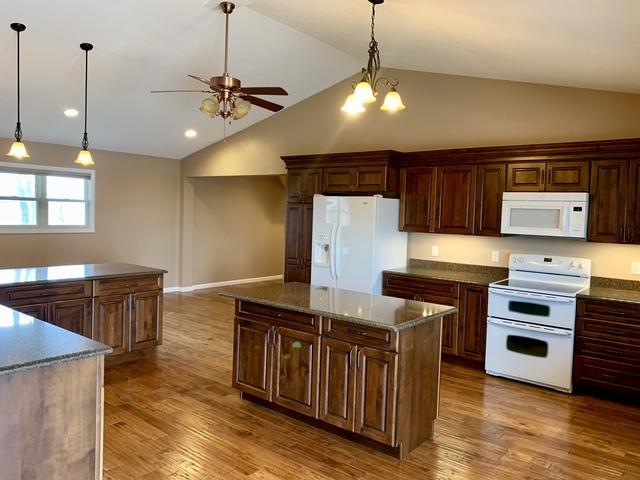 2700 E 600 N Rd, Milford, IL 60953 - kitchen featuring a ceiling fan, lofted ceiling, white appliances, a kitchen island, and wood finished floors