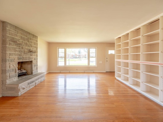 751 Cedar Ln, Chicago Heights, IL 60411 - unfurnished living room featuring a stone fireplace, wood finished floors, and baseboards