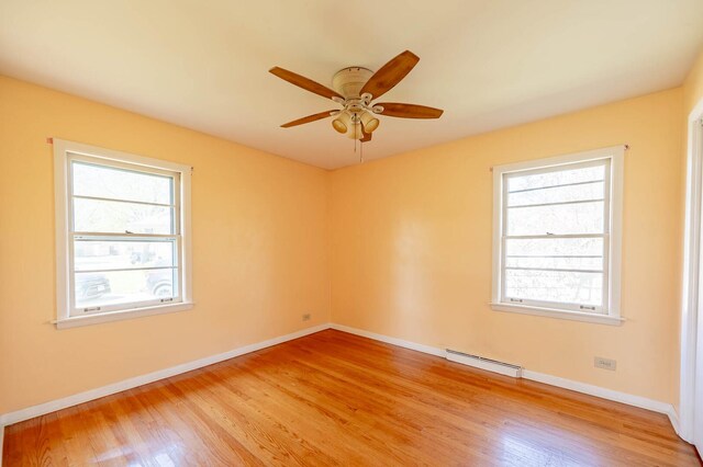 751 Cedar Ln, Chicago Heights, IL 60411 - empty room with a baseboard heating unit, a ceiling fan, baseboards, and light wood-type flooring