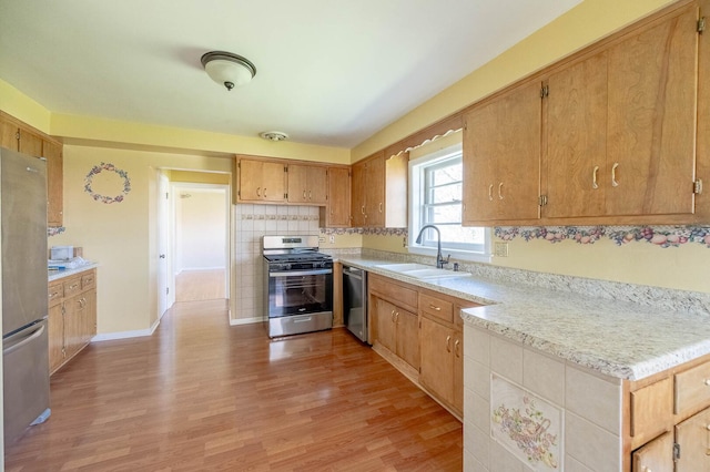 751 Cedar Ln, Chicago Heights, IL 60411 - kitchen with light wood-style flooring, decorative backsplash, stainless steel appliances, light countertops, and a sink