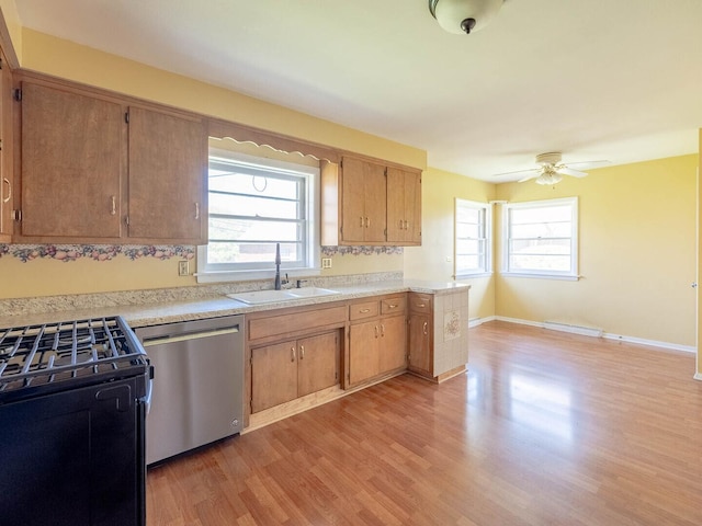 751 Cedar Ln, Chicago Heights, IL 60411 - kitchen with stainless steel dishwasher, light wood-style flooring, a sink, light countertops, and gas stove