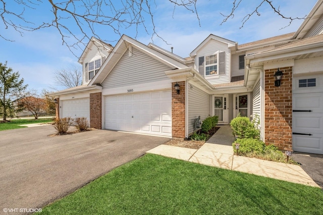 3095 Courtland St Unit 0, Woodstock, IL 60098 - view of property with brick siding, a garage, and aphalt driveway