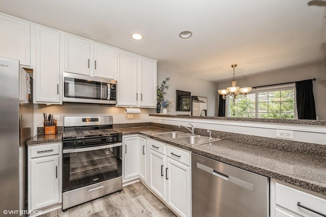 3095 Courtland St Unit 0, Woodstock, IL 60098 - kitchen featuring white cabinets, a chandelier, appliances with stainless steel finishes, and a sink