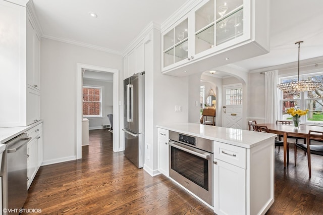 1404 Lincoln St, Evanston, IL 60201 - kitchen featuring dark wood finished floors, arched walkways, appliances with stainless steel finishes, and white cabinetry