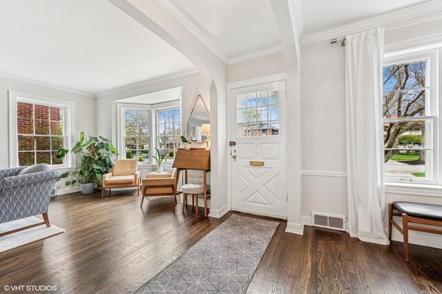 1404 Lincoln St, Evanston, IL 60201 - entrance foyer with dark wood finished floors, visible vents, ornamental molding, arched walkways, and baseboards