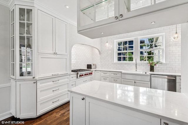 1404 Lincoln St, Evanston, IL 60201 - kitchen featuring stainless steel appliances, a sink, dark wood-type flooring, tasteful backsplash, and white cabinetry