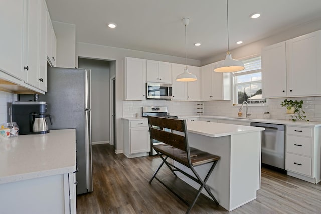9303 Enstrom Ln, Huntley, IL 60142 - kitchen with stainless steel appliances, decorative backsplash, white cabinetry, dark wood finished floors, and recessed lighting