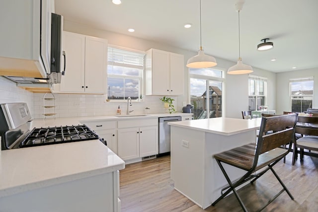 9303 Enstrom Ln, Huntley, IL 60142 - kitchen with appliances with stainless steel finishes, a breakfast bar area, tasteful backsplash, light wood finished floors, and white cabinets