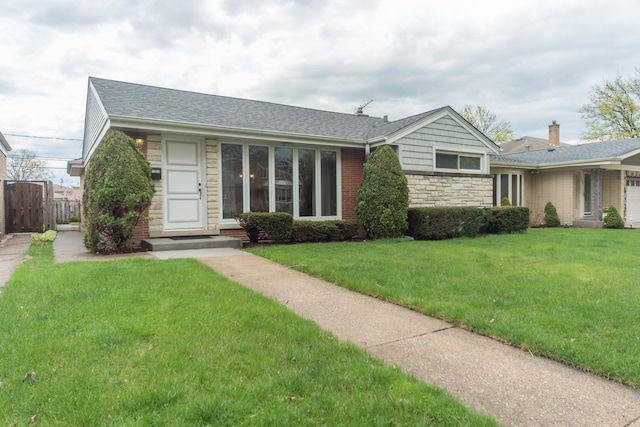 ranch-style home with roof with shingles, stone siding, a front yard, and fence