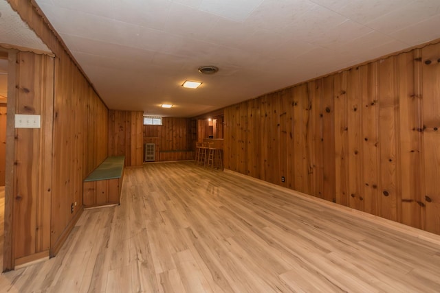 interior space featuring wood walls and light wood finished floors