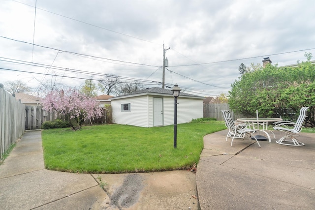 view of yard with a fenced backyard, an outdoor structure, a patio area, and outdoor dining area