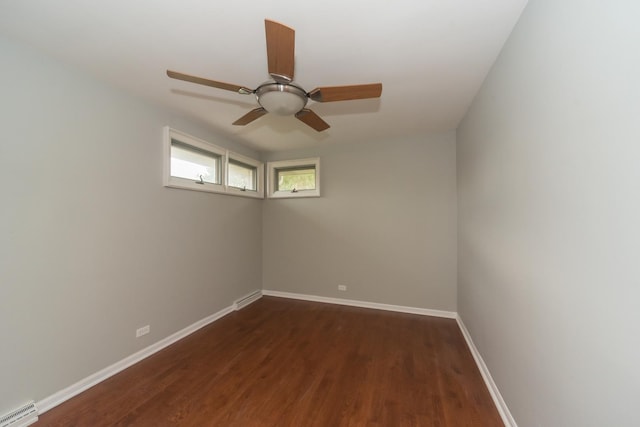 empty room featuring visible vents, dark wood-type flooring, baseboards, baseboard heating, and ceiling fan