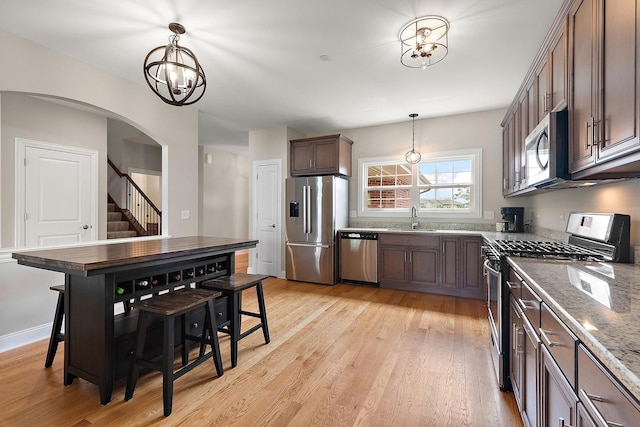 9356 Parkwood Ln, Tinley Park, IL 60487 - kitchen featuring appliances with stainless steel finishes, a chandelier, a sink, pendant lighting, and arched walkways