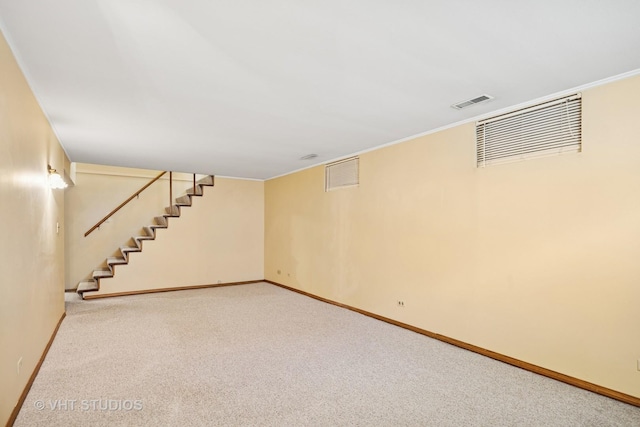 finished below grade area featuring baseboards, carpet, and stairway