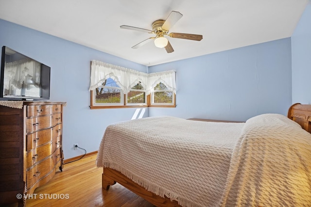bedroom featuring wood finished floors, baseboards, and a ceiling fan