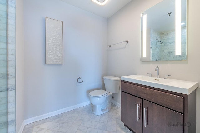 bathroom with a tile shower, baseboards, toilet, and vanity