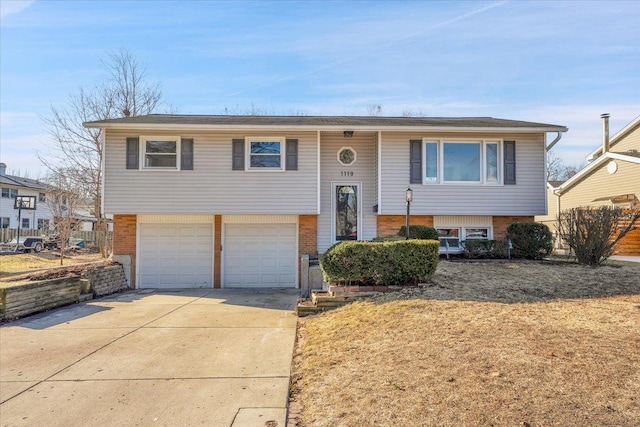 bi-level home with brick siding, driveway, and a garage