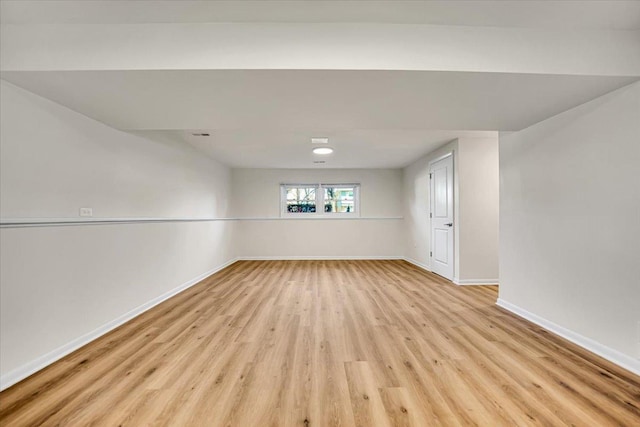 unfurnished room with light wood-type flooring and baseboards
