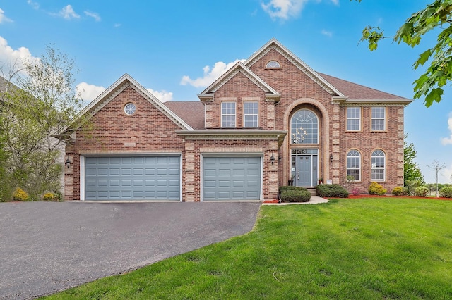 traditional-style house with brick siding, a front lawn, and aphalt driveway