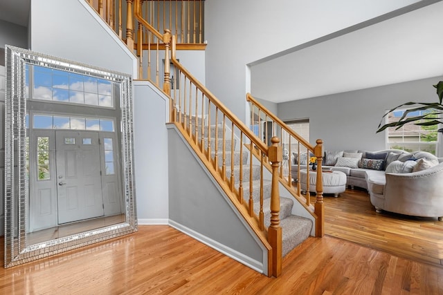 entryway with a high ceiling, wood finished floors, and a wealth of natural light