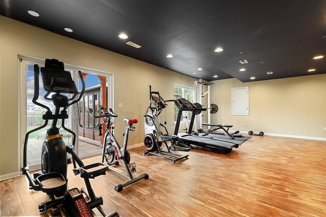 exercise room featuring baseboards, recessed lighting, light wood-style flooring, and visible vents