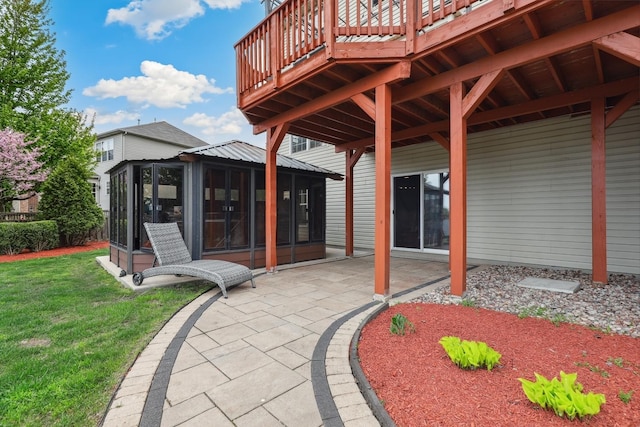 view of patio featuring a wooden deck, a gazebo, and a sunroom