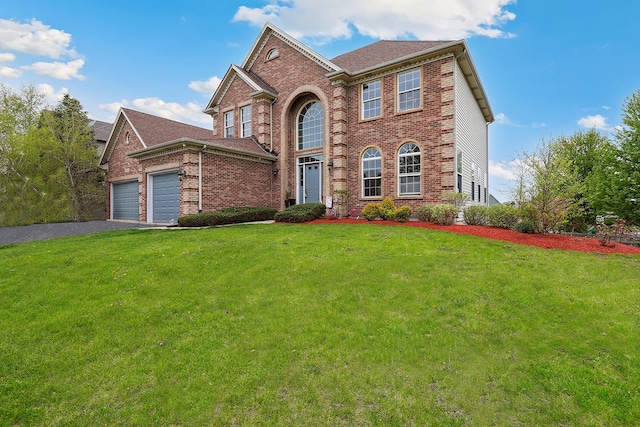 traditional home featuring brick siding, a garage, aphalt driveway, and a front yard
