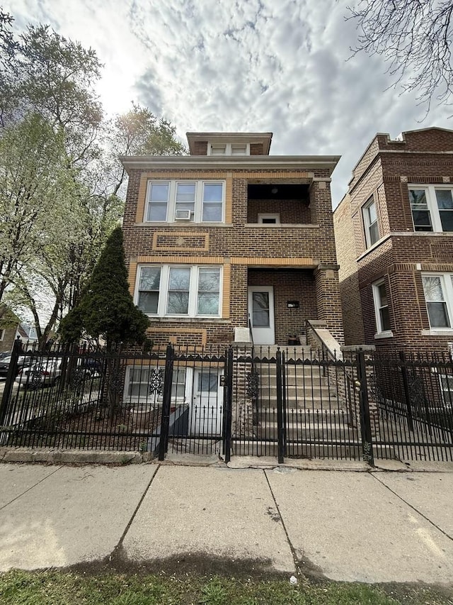 view of front facade with brick siding, a balcony, and a fenced front yard