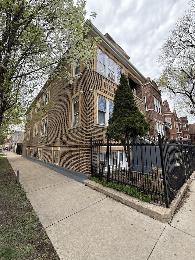 view of side of home with brick siding and fence private yard