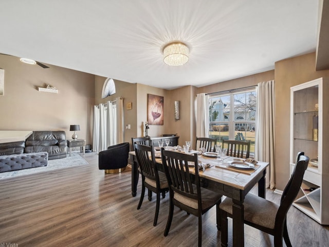 dining room with wood finished floors and a notable chandelier