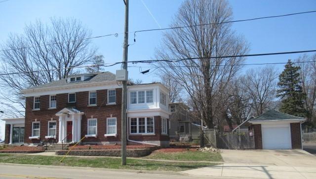 colonial home featuring fence, driveway, and brick siding