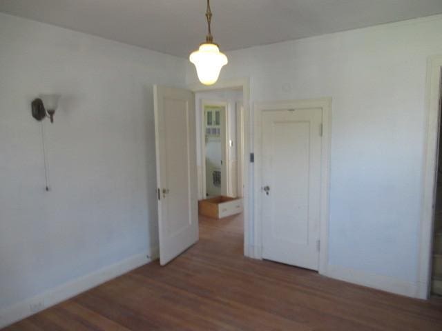 unfurnished dining area featuring baseboards and wood finished floors