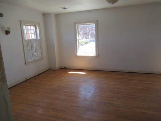 empty room with baseboards and wood finished floors