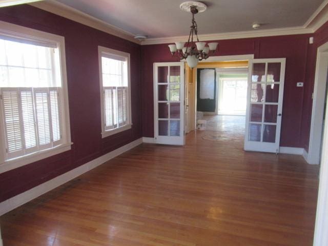 unfurnished dining area with crown molding, baseboards, plenty of natural light, and a chandelier