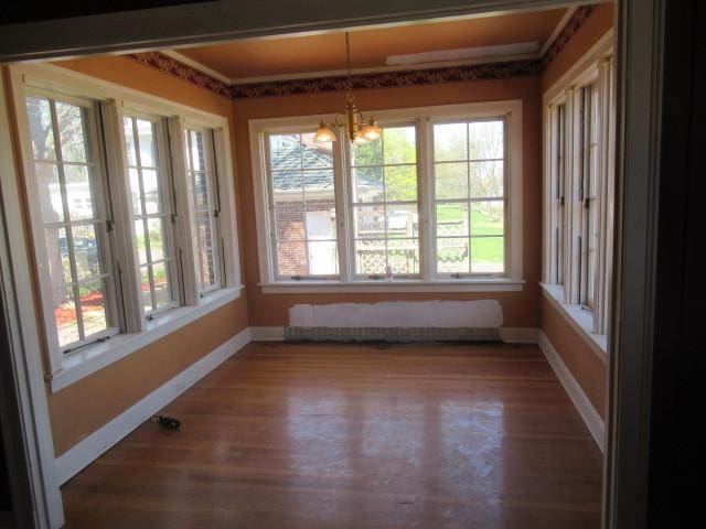unfurnished sunroom featuring an inviting chandelier and french doors