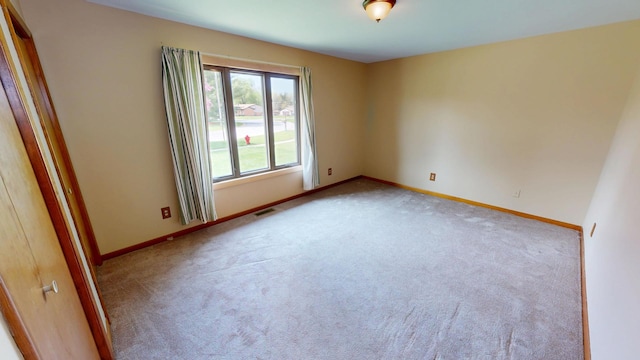 spare room with baseboards, carpet, and visible vents