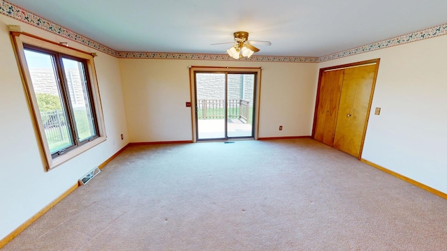 unfurnished room with baseboards, ceiling fan, light colored carpet, and visible vents