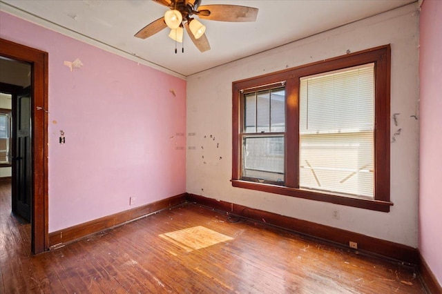 spare room featuring wood-type flooring, ceiling fan, and baseboards