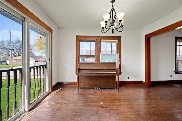interior space featuring a notable chandelier, a wealth of natural light, wood finished floors, and baseboards
