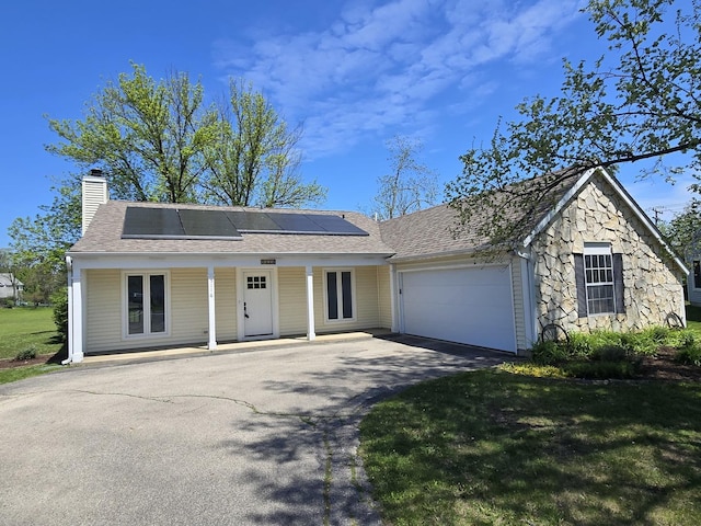 5116 Beechwood Ave, Gurnee, IL 60031 - view of front of property featuring asphalt driveway, an attached garage, a chimney, roof mounted solar panels, and a porch