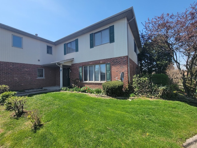 view of front of property featuring a front yard and brick siding