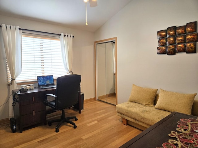 office featuring baseboards, ceiling fan, light wood-type flooring, and lofted ceiling